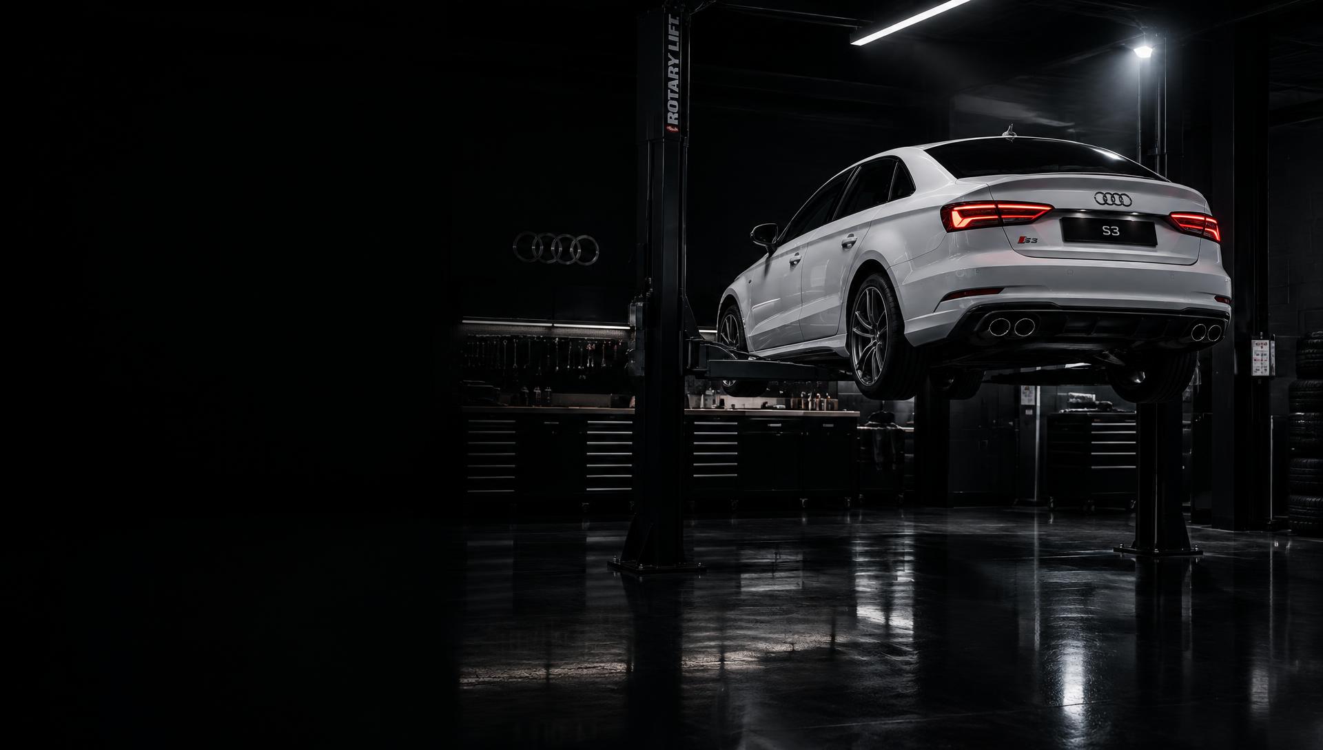 Audi S3 branco em elevador em oficina escura